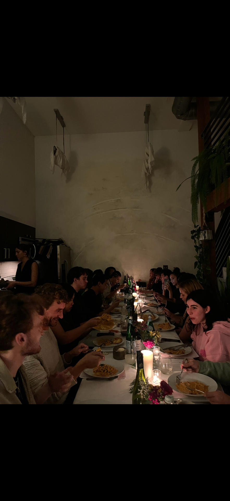 Long candlelit dinner table at a Frontier NYC backyard event
